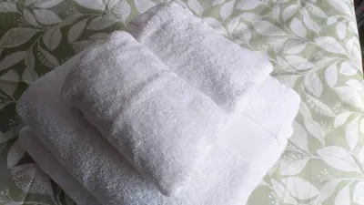 a stack of white towels sitting on a bed at Foz Beach Home in Foz