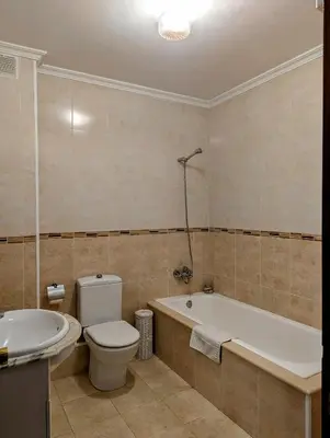 a bathroom with a toilet and a tub and a sink at Foz Beach Home in Foz