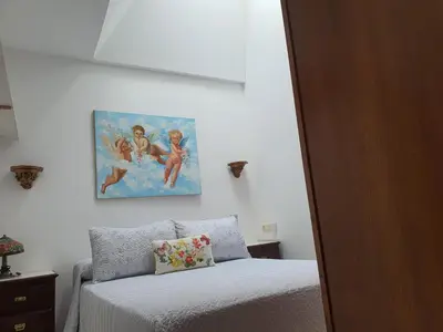 a bedroom with a bed and a painting on the wall at Medieval Gem in Santiago de Compostela