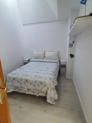 a bedroom with a bed in a white room at Medieval Gem in Santiago de Compostela