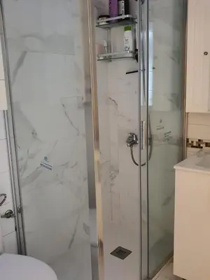a shower with a glass door in a bathroom at Medieval Gem in Santiago de Compostela