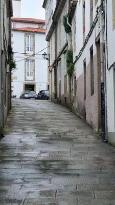 an empty street in an alley with buildings at Medieval Gem in Santiago de Compostela