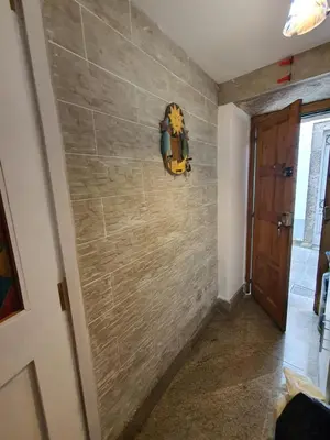 a hallway with a stone wall with a door at Medieval Gem in Santiago de Compostela