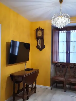 a room with a tv and a table and a clock at Medieval Gem in Santiago de Compostela