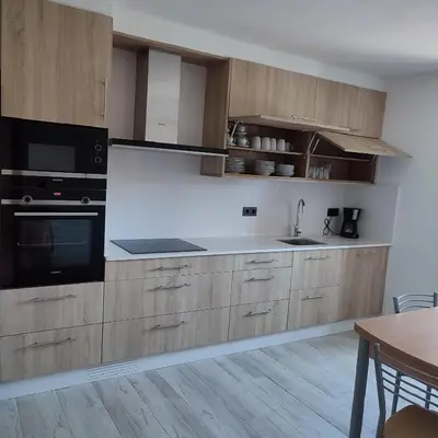 a kitchen with wooden cabinets and a sink at O Lar da Crega in O Pino