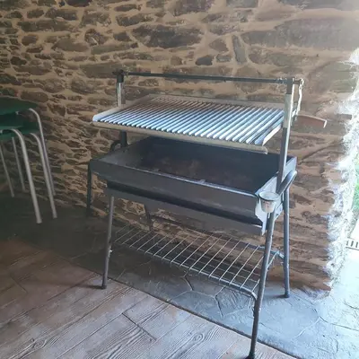 a piano sitting in a room with a brick wall at O Lar da Crega in O Pino