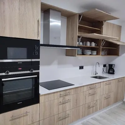 a kitchen with black appliances and wooden cabinets at O Lar da Crega in O Pino