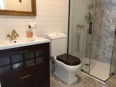 a bathroom with a toilet with a sink and a shower at Estudios rúa Maior, 49-2B in Sarria