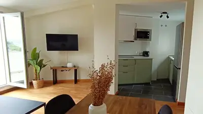 a living room with a table and a kitchen at AYE Catedrales in Barreiros