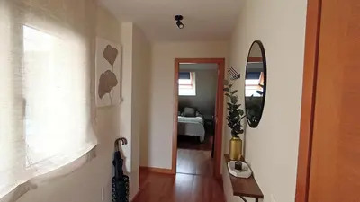 a hallway with a mirror and a room with a bed at AYE Catedrales in Barreiros