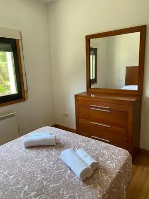 a bedroom with a bed with a dresser and a mirror at Carballeira in Moraña