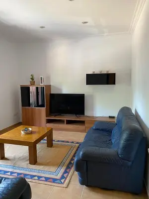 a living room with a blue couch and a table at Carballeira in Moraña