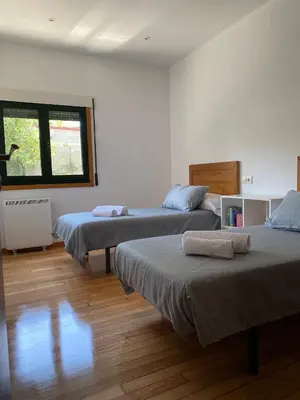a bedroom with two beds and a window at Carballeira in Moraña