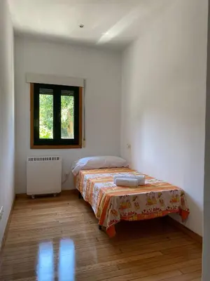 a white room with a bed and a window at Carballeira in Moraña