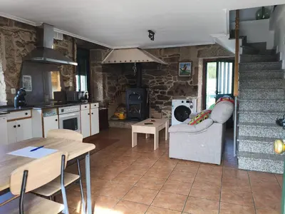 a kitchen with a couch and a table and a stove at As Lamelas in Cea