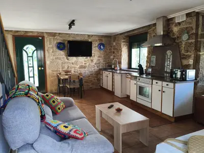 a living room with a couch and a kitchen at As Lamelas in Cea
