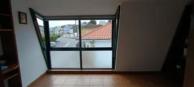 an open glass door with a view of a street at As Lamelas in Cea