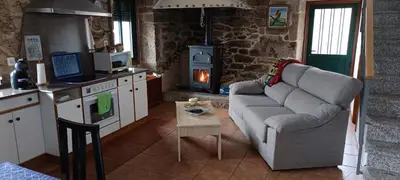 a living room with a couch and a stove at As Lamelas in Cea