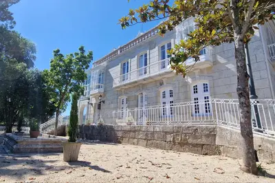 a large white building with a tree in front of it at Casa Palacio Ribeira Sacra in Esgos
