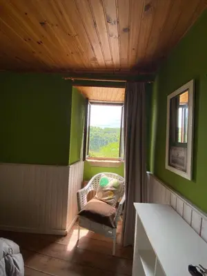 a green room with a chair and a window at Casa Rural Santa Mariña in Portomarin