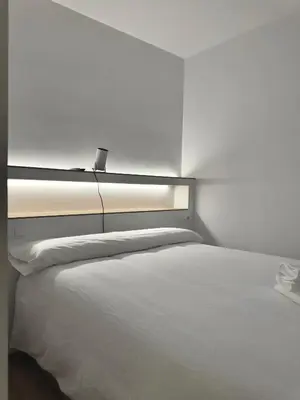 a bedroom with a white bed with a light on it at Kilometro 22 Luxury in Padrón