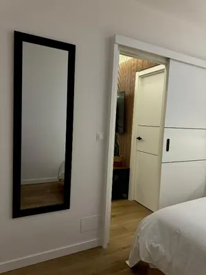 a bedroom with a mirror next to a bed at Kilometro 22 Luxury in Padrón
