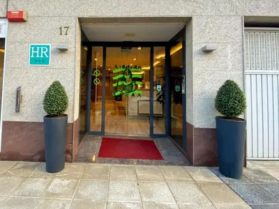 a building with two potted plants in front of a door at Hotel Ribeira Sacra in Monforte de Lemos