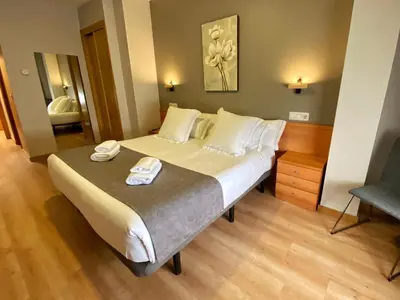 a bedroom with a bed and a chair in a room at Hotel Ribeira Sacra in Monforte de Lemos