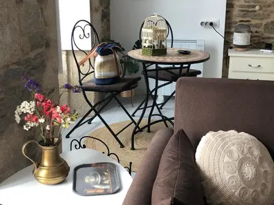 a living room with a couch and a table with flowers at Estudios rúa Maior, 49-2A in Sarria