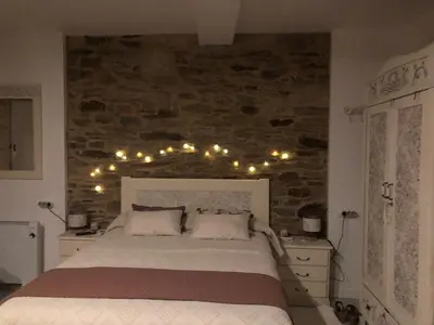 a bedroom with a bed with lights on the wall at Estudios rúa Maior, 49-2A in Sarria