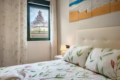 a bedroom with a bed with a view of a building at Apartamentos Marta in Ribadeo