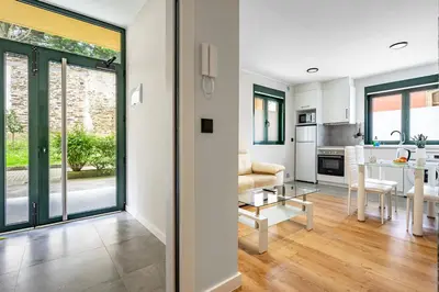 a kitchen and living room with sliding glass doors and a table at Apartamentos Marta in Ribadeo