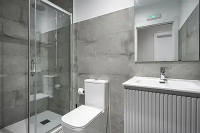 a bathroom with a toilet and a sink and a shower at Apartamentos Marta in Ribadeo