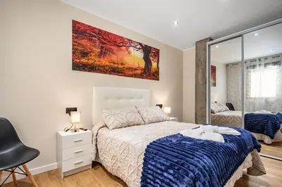 a bedroom with a bed and a large painting on the wall at Apartamentos Marta in Ribadeo