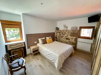 a bedroom with a bed and a chair in it at A Casa Do Cuarto in Irijoa