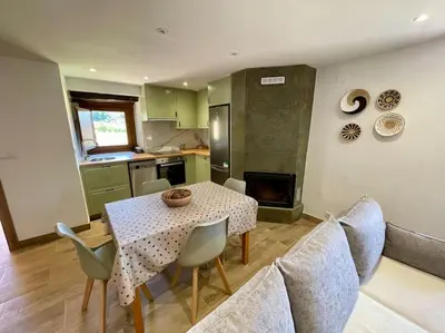 a kitchen and dining room with a table and chairs at A Casa Do Cuarto in Irijoa