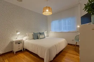 a bedroom with a white bed and a window at Travesa in Betanzos
