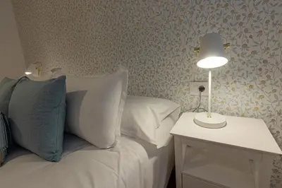 a bedroom with a bed with a lamp on a night stand at Travesa in Betanzos