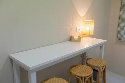 a white counter with two stools and a lamp at Travesa in Betanzos