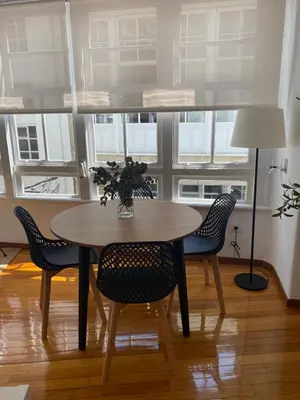 a dining room with a table and chairs and windows at Travesa in Betanzos