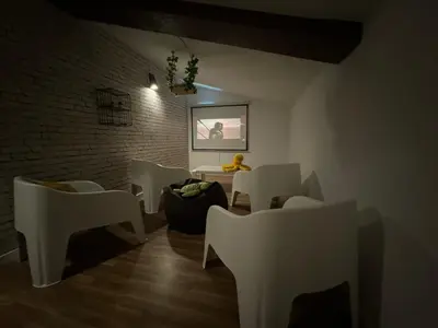 a room with white chairs and a table and a brick wall at Chalet Abelleira Playa Barreiros in Barreiros