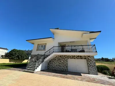 a white house with a balcony and a garage at Chalet Abelleira Playa Barreiros in Barreiros