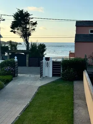 a house on the beach with the ocean in the background at Chalet Abelleira Playa Barreiros in Barreiros