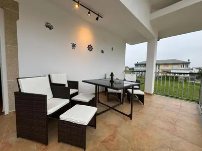 a patio with a dining table and chairs and a table and chairsktop at Chalet Abelleira Playa Barreiros in Barreiros