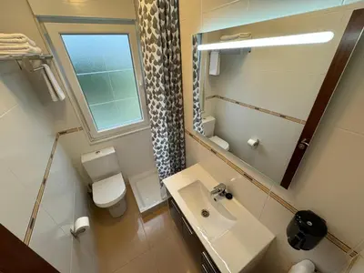 a bathroom with a sink and a toilet and a mirror at Chalet Abelleira Playa Barreiros in Barreiros