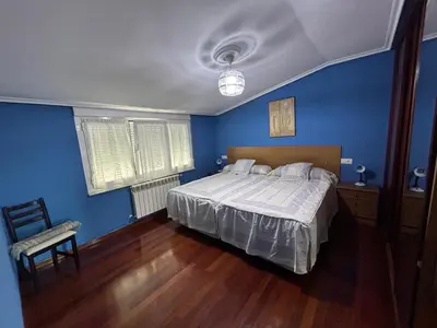 a blue bedroom with a bed and a chair at Estupenda casa cercana a la playa y a la montaña VUT6678AS in La Caridad