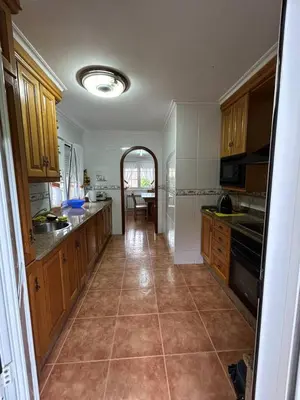 a kitchen with wooden cabinets and a tile floor at Estupenda casa cercana a la playa y a la montaña VUT6678AS in La Caridad