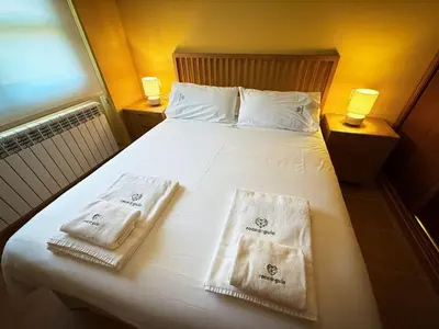 a bedroom with a bed with two towels on it at Roca de Guía Somiedo in Pola de Somiedo
