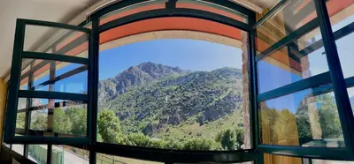 an open window with a view of a mountain at Roca de Guía Somiedo in Pola de Somiedo