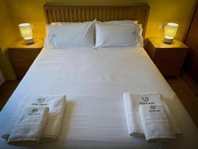 a bedroom with a bed with towels on it at Roca de Guía Somiedo in Pola de Somiedo